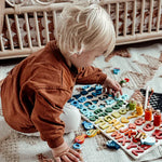 Wooden play board for promoting skills according to Montessori principles