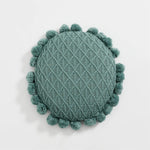 Round plush cushion with pompom and tassel in acrylic knit