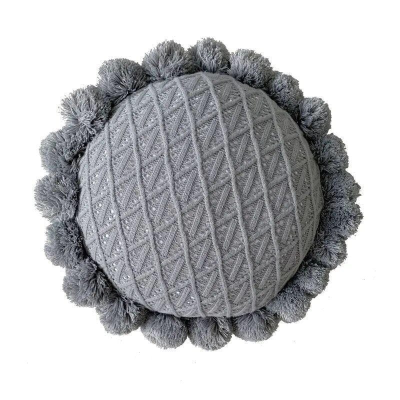 Round plush cushion with pompom and tassel in acrylic knit