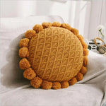 Round plush cushion with pompom and tassel in acrylic knit