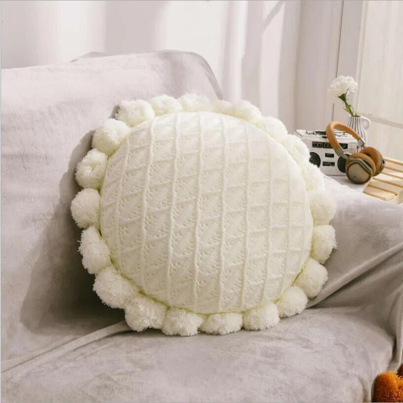 Round plush cushion with pompom and tassel in acrylic knit