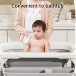 Compact changing table with height adjustment and integrated bath