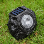 Solar-powered LED garden light in stone design with light sensor
